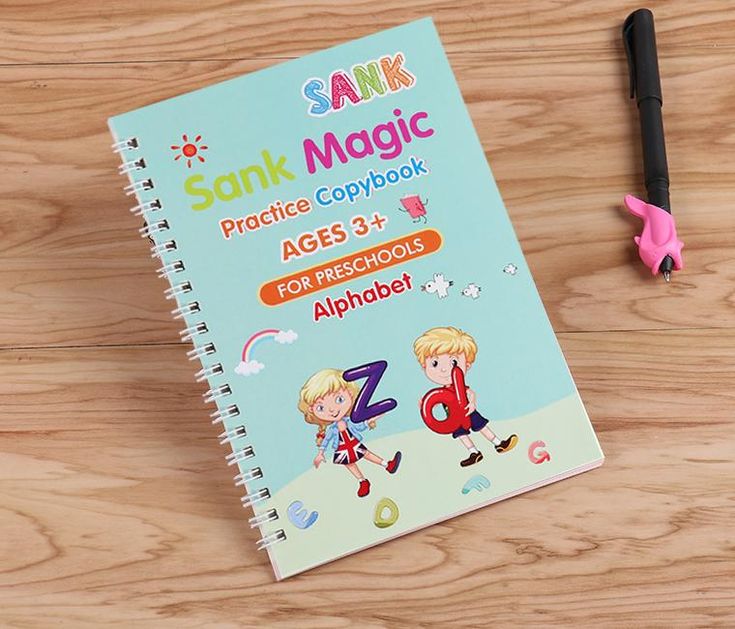 Children's practice copybook titled 'Sank Magic' on a wooden surface with a pen and eraser.