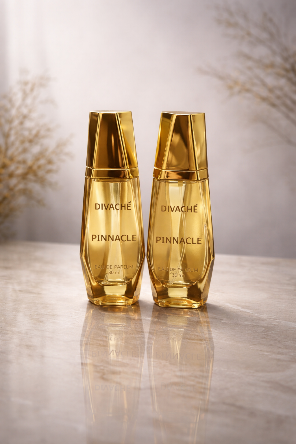 Two gold bottles of Divache Pinnacle on a reflective surface with a blurred background