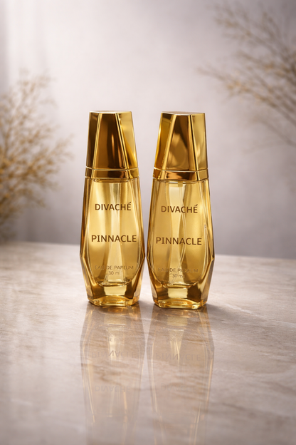 Two gold bottles of Divache Pinnacle on a reflective surface with a blurred background